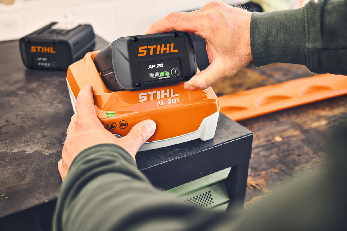 Batteria Stihl AP 20 inserita in un caricabatterie Stihl AL 301, con indicatore LED acceso