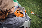 Persona che utilizza il caricabatterie STIHL AL 1802 MO su un rimorchio