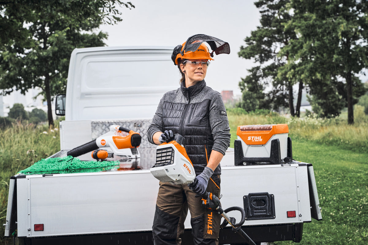 Operatrice davanti a un rimorchio con caricabatterie STIHL AL 1802 MO e utensili