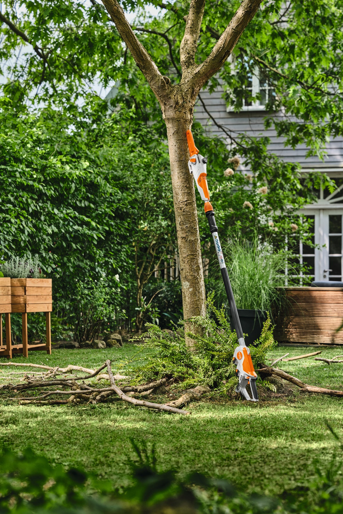 Potatore telescopico Stihl HTA 30 appoggiato a un albero in giardino