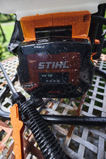 Dettaglio della batteria inserita nell'irroratore con gocce d'acqua sul corpo batteria.