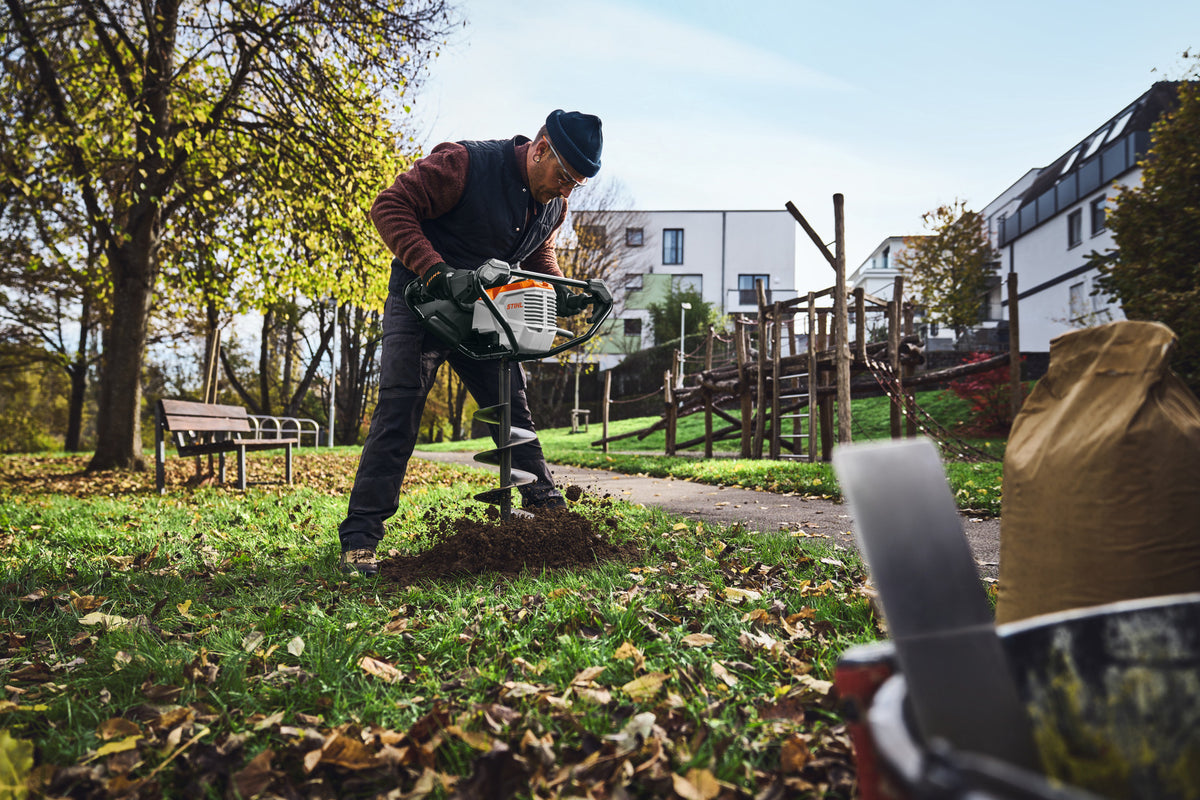 Operatore che utilizza la trivella a batteria Stihl BTA 140 su un prato
