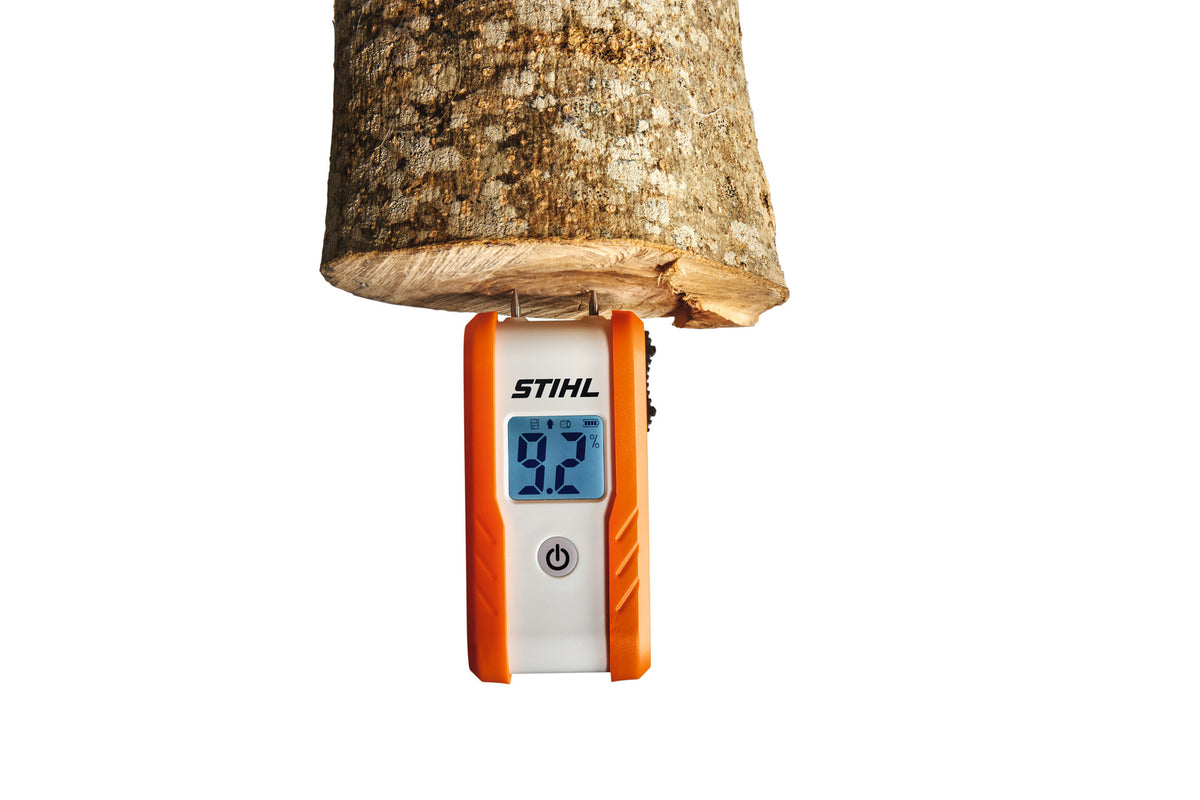 Misuratore di umidità Stihl con le punte a contatto con la sezione tagliata di un pezzo di legno