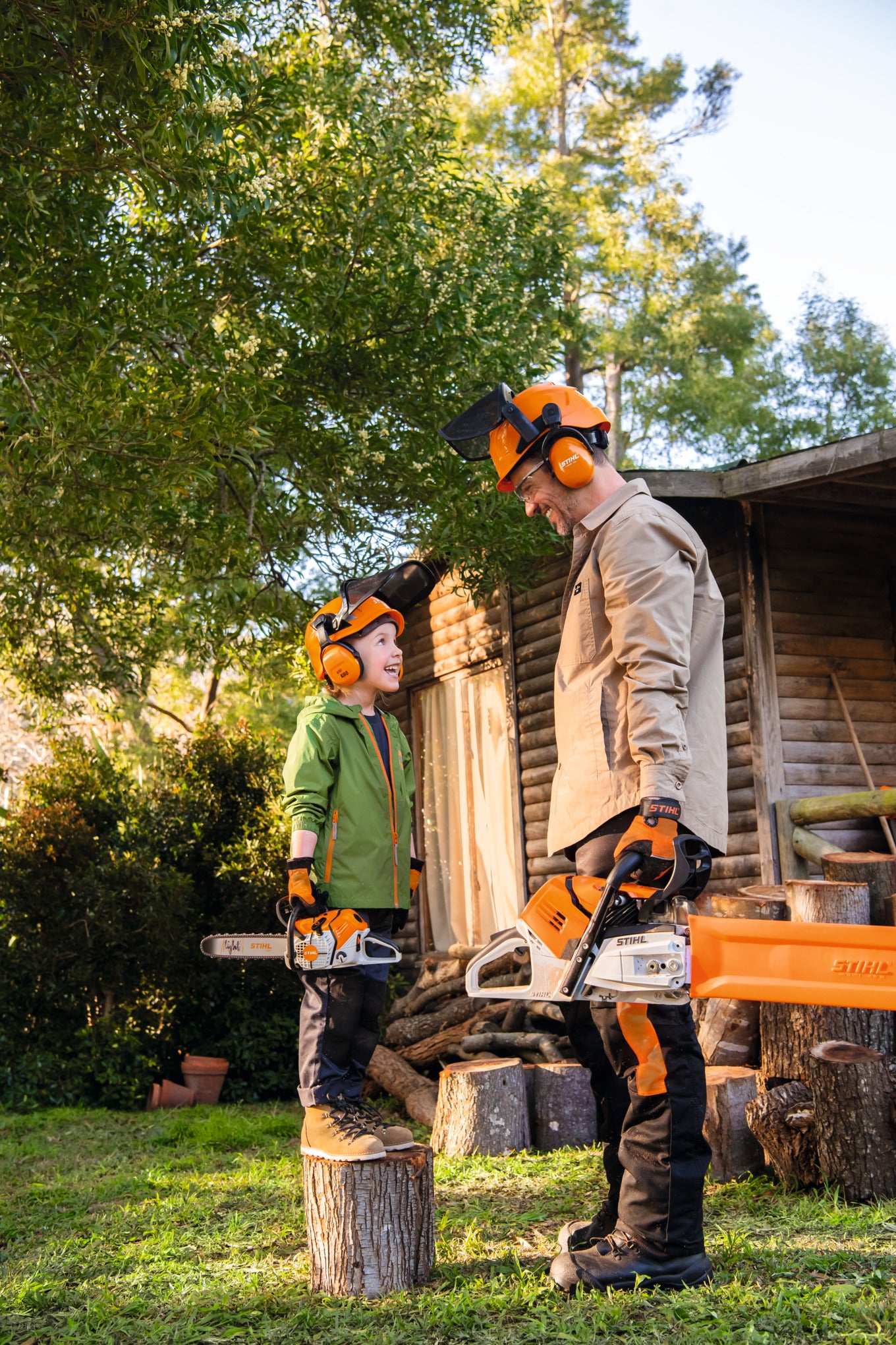 Adulto e bambino con motosega giocattolo Stihl a batterie in giardino