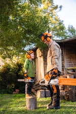 Adulto e bambino con motosega giocattolo Stihl a batterie in giardino