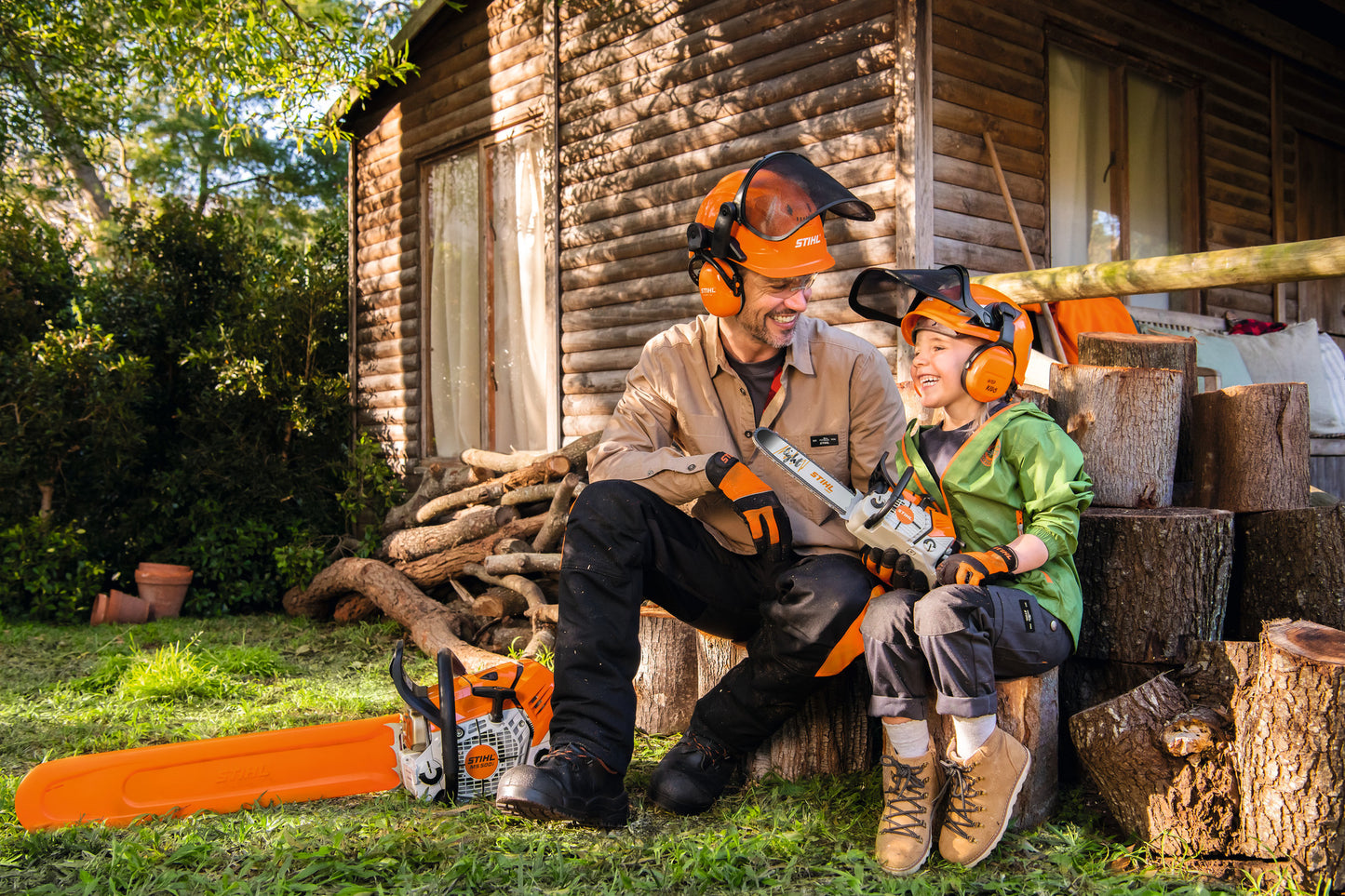 Bambino con motosega giocattolo Stihl a batterie in contesto outdoor