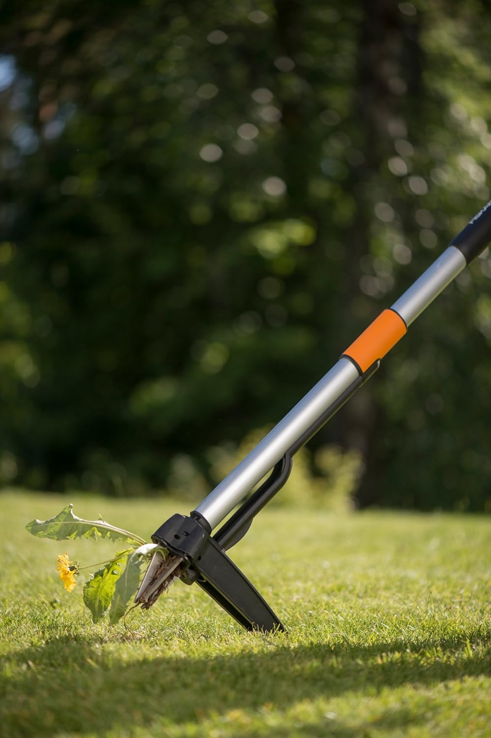 Estirpatore Fiskars SmartFit in uso su prato vicino al terreno