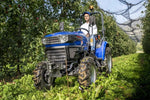 Trattore compatto Farmtrac 4RM vista anteriore in frutteto
