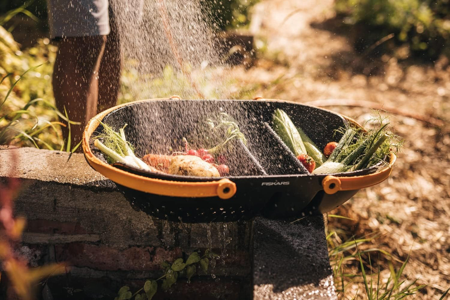 Cesta Fiskars Plus con ortaggi lavati e drenaggio dell’acqua
