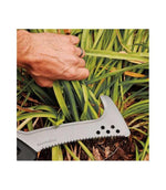 Dettaglio roncola seghettata Fiskars Solid in uso su vegetazione fitta