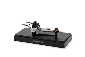 Modellino motosega d’epoca Stihl Typ A in scala 1:12 su basamento con cappuccio trasparente