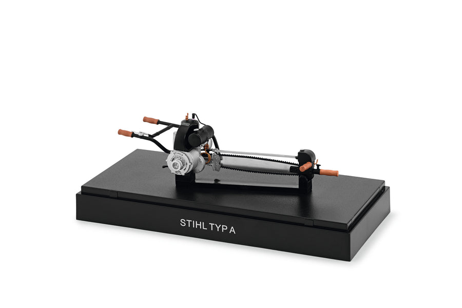 Modellino motosega d’epoca Stihl Typ A in scala 1:12 su basamento con cappuccio trasparente