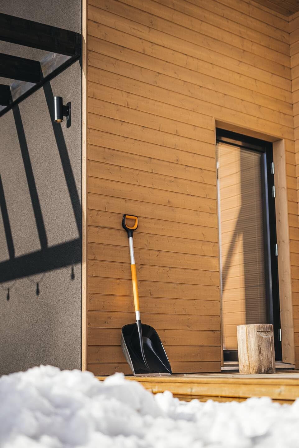 Pala da neve Fiskars X-Series appoggiata all'esterno