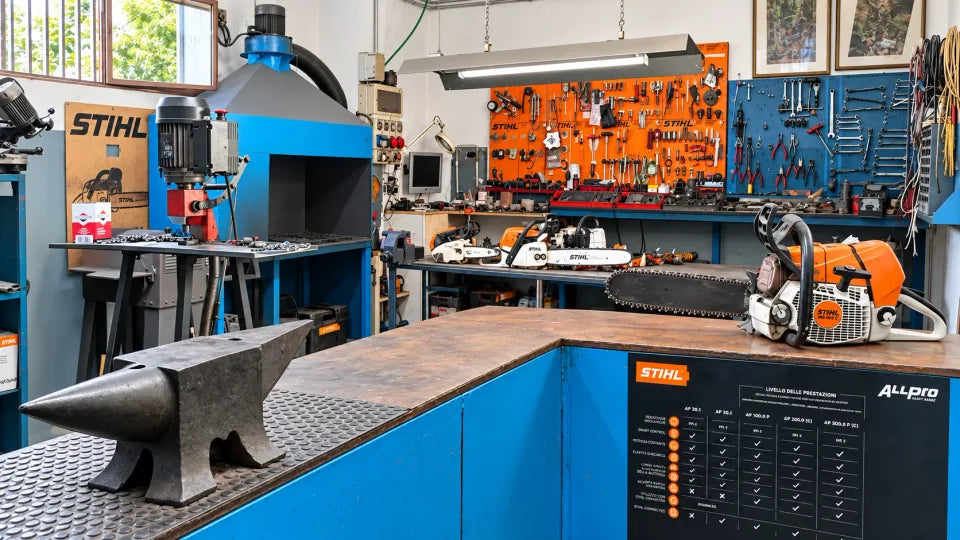 Banco officina con motoseghe STIHL, utensili e attrezzature per la manutenzione.